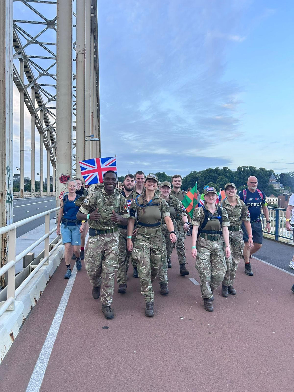 The team marching out of Nijmegen across a bridge and into the countryside.